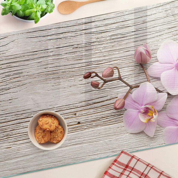 Szklana deska kuchenna z motywem orchidei na tle drewna