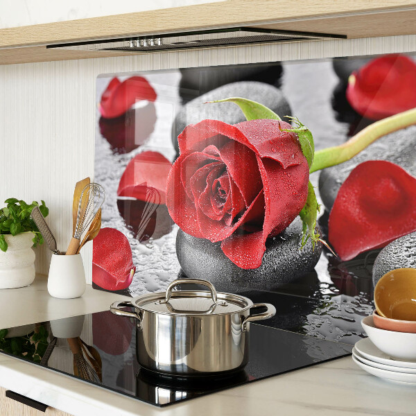 Szklana deska kuchenna z motywem róży na kamieniach z kroplami wody