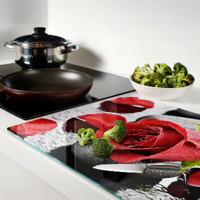 Szklana deska kuchenna z motywem róży na kamieniach z kroplami wody