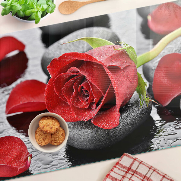 Szklana deska kuchenna z motywem róży na kamieniach z kroplami wody