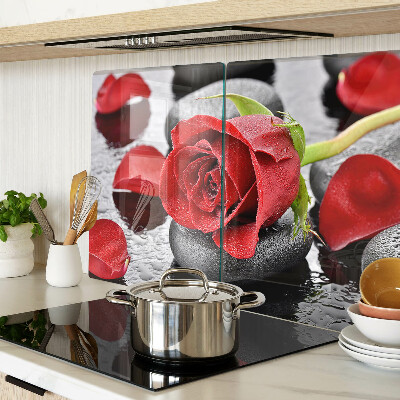 Szklana deska kuchenna z motywem róży na kamieniach z kroplami wody