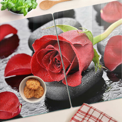 Szklana deska kuchenna z motywem róży na kamieniach z kroplami wody