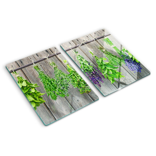 Szklana deska kuchenna z motywem suszonych ziół na tle drewna