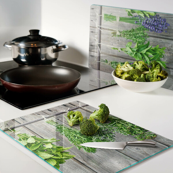Szklana deska kuchenna z motywem suszonych ziół na tle drewna
