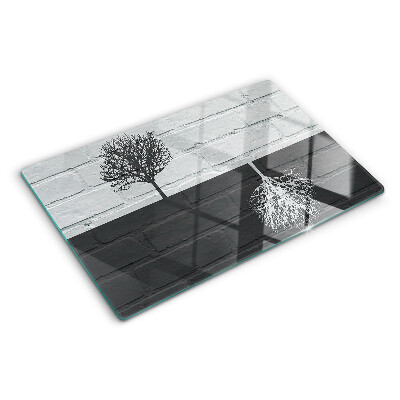 Szklana deska do krojenia z motywem drzewa na tle cegieł