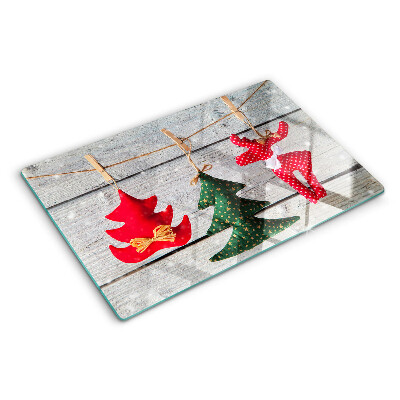 Szklana deska do krojenia z motywem świątecznych ozdób na tle drewnianej powierzchni