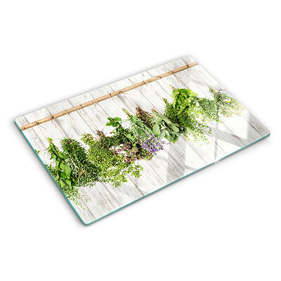 Szklana deska do krojenia z motywem ziół na tle drewnianym