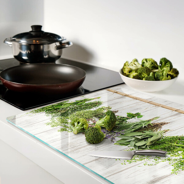 Szklana deska do krojenia z motywem ziół na tle drewnianym