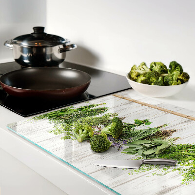 Szklana deska do krojenia z motywem ziół na tle drewnianym