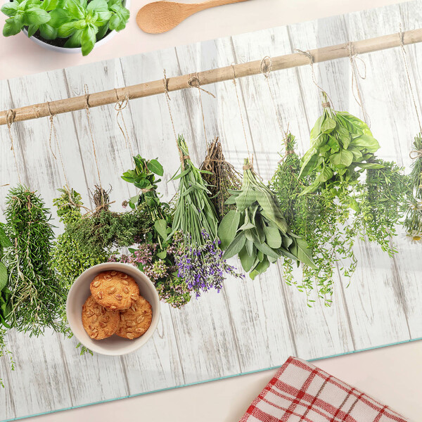 Szklana deska do krojenia z motywem ziół na tle drewnianym