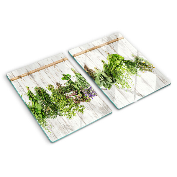 Szklana deska do krojenia z motywem ziół na tle drewnianym