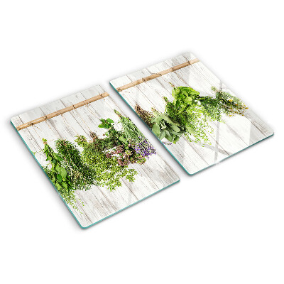 Szklana deska do krojenia z motywem ziół na tle drewnianym