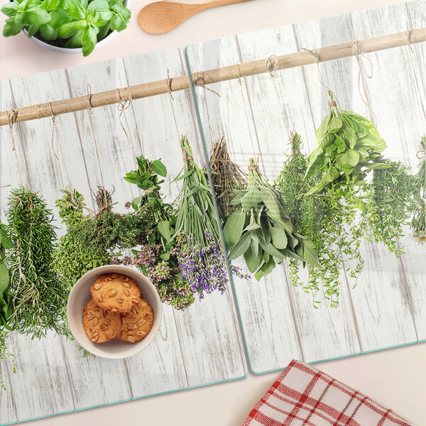 Szklana deska do krojenia z motywem ziół na tle drewnianym