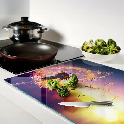 Szklana deska do krojenia z motywem dmuchawców na tle zachodu słońca