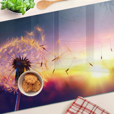 Szklana deska do krojenia z motywem dmuchawców na tle zachodu słońca