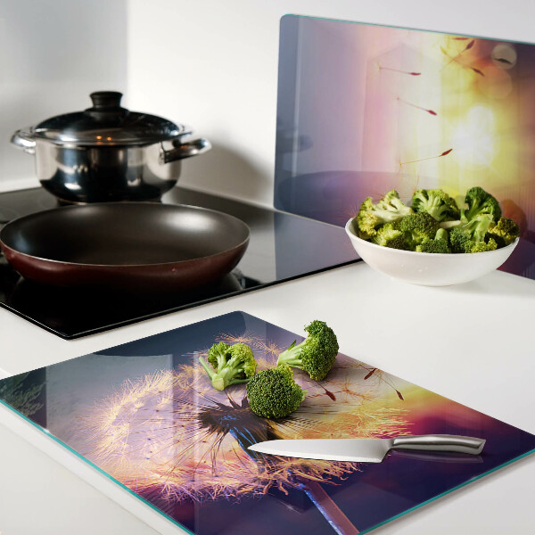 Szklana deska do krojenia z motywem dmuchawców na tle zachodu słońca