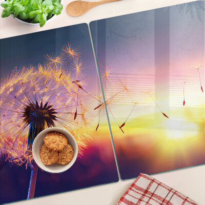 Szklana deska do krojenia z motywem dmuchawców na tle zachodu słońca