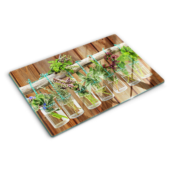 Szklana deska kuchenna z motywem ziół w słoikach na tle drewna