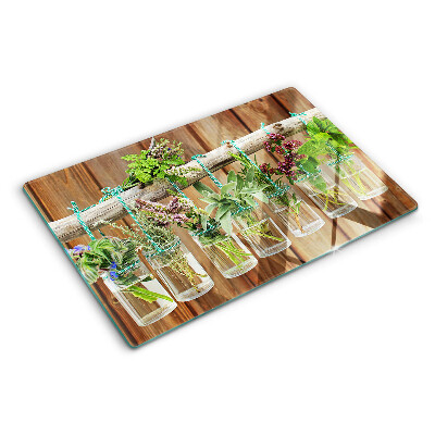 Szklana deska kuchenna z motywem ziół w słoikach na tle drewna