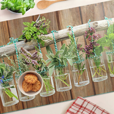 Szklana deska kuchenna z motywem ziół w słoikach na tle drewna