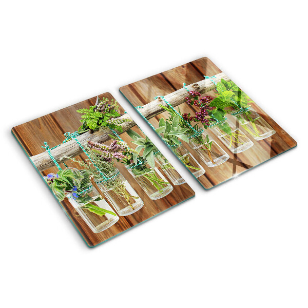 Szklana deska kuchenna z motywem ziół w słoikach na tle drewna