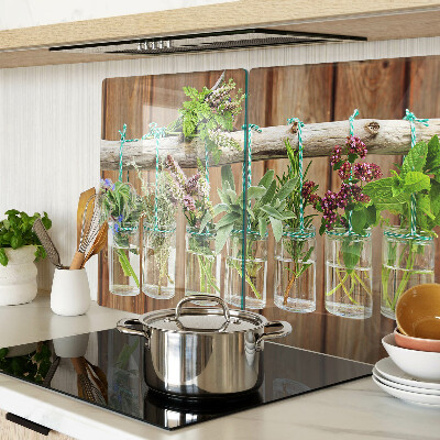 Szklana deska kuchenna z motywem ziół w słoikach na tle drewna