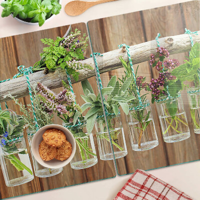 Szklana deska kuchenna z motywem ziół w słoikach na tle drewna