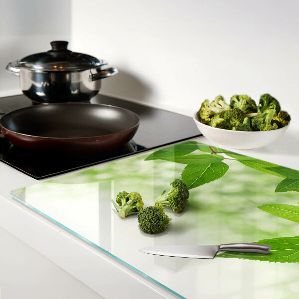 Szklana deska kuchenna z motywem liści na tle rozmytej zieleni