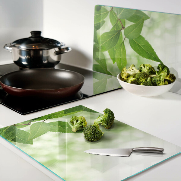 Szklana deska kuchenna z motywem liści na tle rozmytej zieleni