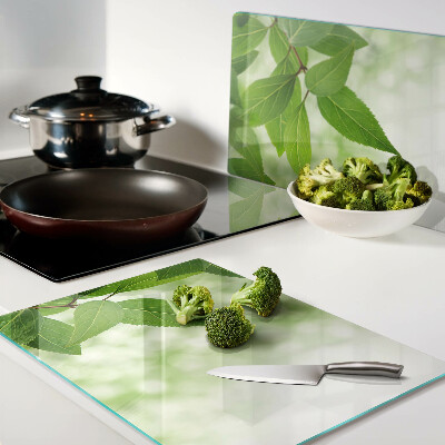 Szklana deska kuchenna z motywem liści na tle rozmytej zieleni