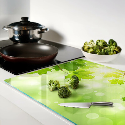 Szklana deska do krojenia z motywem liści w promieniach słońca