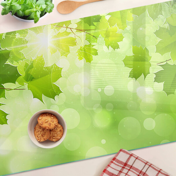 Szklana deska do krojenia z motywem liści w promieniach słońca