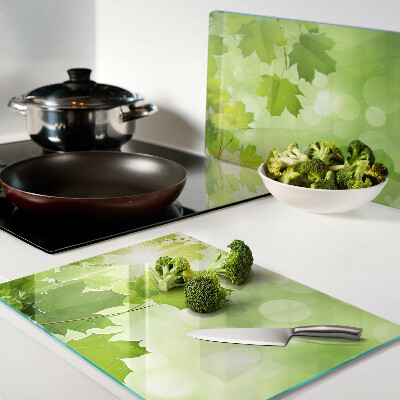 Szklana deska do krojenia z motywem liści w promieniach słońca