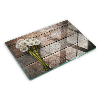 Szklana deska kuchenna z motywem dmuchawców na tle drewna