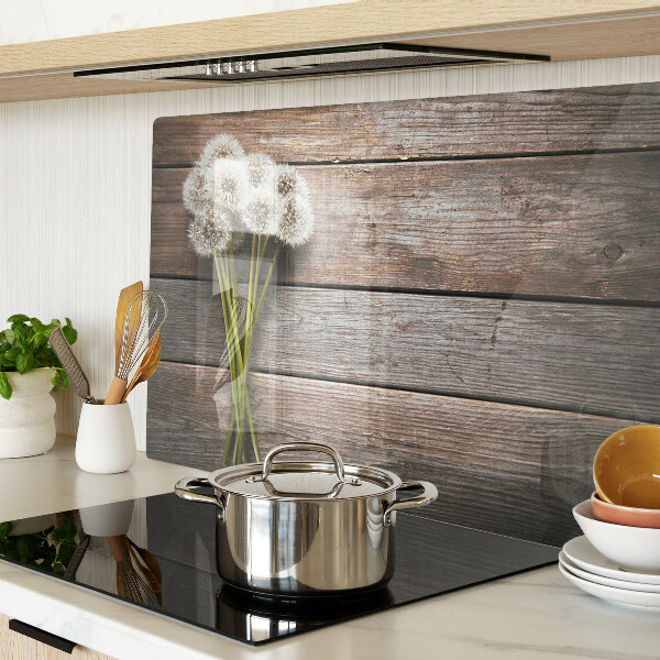 Szklana deska kuchenna z motywem dmuchawców na tle drewna