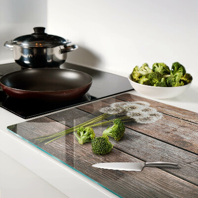 Szklana deska kuchenna z motywem dmuchawców na tle drewna