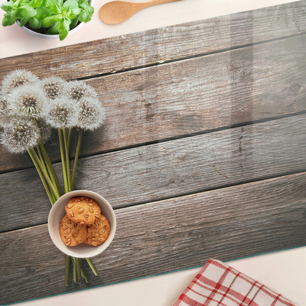 Szklana deska kuchenna z motywem dmuchawców na tle drewna