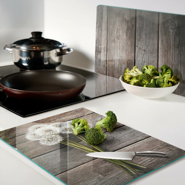 Szklana deska kuchenna z motywem dmuchawców na tle drewna