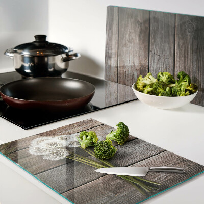 Szklana deska kuchenna z motywem dmuchawców na tle drewna