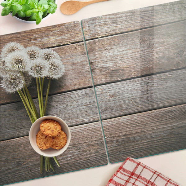 Szklana deska kuchenna z motywem dmuchawców na tle drewna