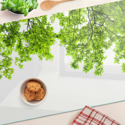 Szklana deska kuchenna z motywem zielonych liści na tle nieba