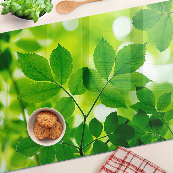 Deska kuchenna szklana z motywem liści na zielonym tle