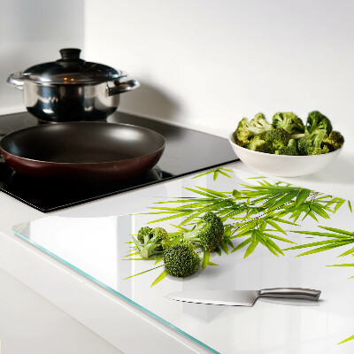 Szklana deska kuchenna z motywem liści bambusa widocznych na tle okna