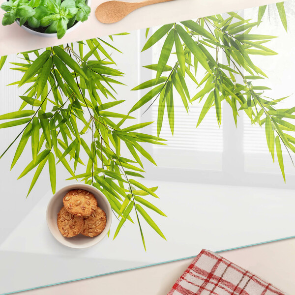 Szklana deska kuchenna z motywem liści bambusa widocznych na tle okna