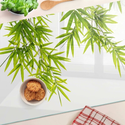 Szklana deska kuchenna z motywem liści bambusa widocznych na tle okna