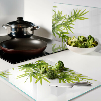 Szklana deska kuchenna z motywem liści bambusa widocznych na tle okna