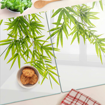Szklana deska kuchenna z motywem liści bambusa widocznych na tle okna