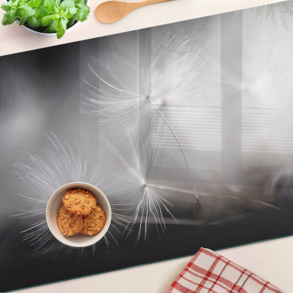 Szklana deska kuchenna z motywem puszystych dmuchawców widocznych na tle okna