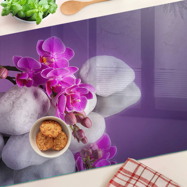 Deska kuchenna szklana z motywem kwiatów orchidei na tle kamieni
