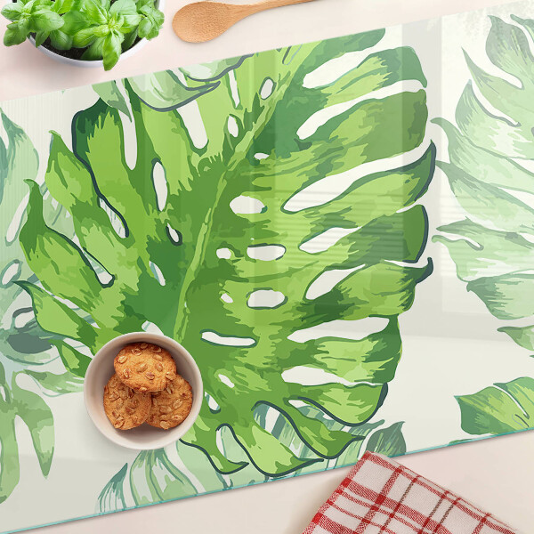 Deska kuchenna szklana z motywem liści monstery na jasnym tle